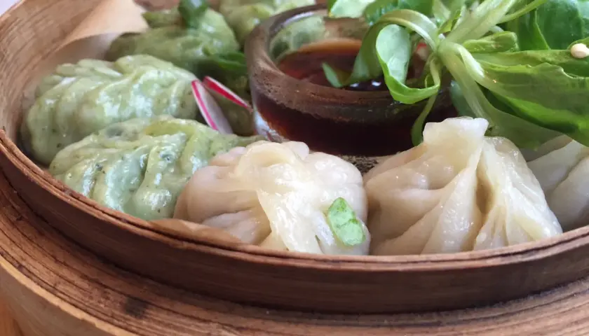 Parowóz z dim sum: zielone i białe pierożki z sosem i sałatką.
