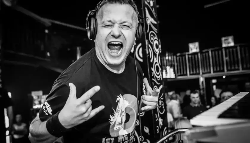 DJ Hazel w akcji, z mikrofonem i słuchawkami, krzyczy do publiczności. Sprawdź jego dj hazel cennik na imprezy!