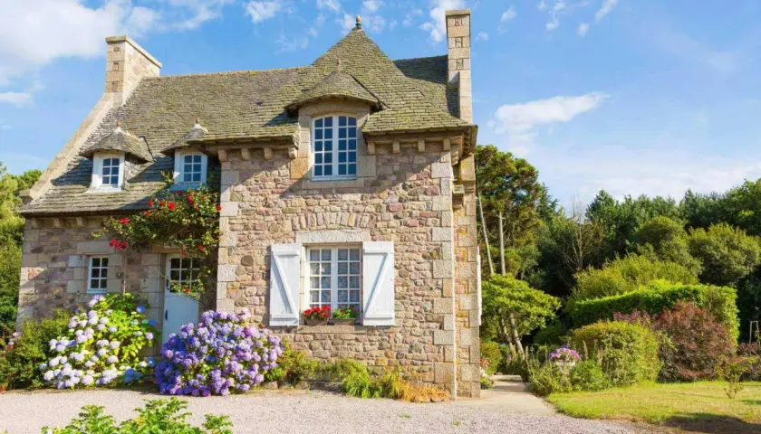 Charmante maison en pierre, fleuron d'un projet de cout renovation maison ancienne. Hydrangeas bleues et roses égaient l'entrée.