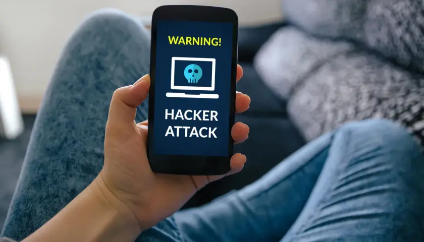 Ostrzeżenie na ekranie telefonu: "HACKER ATTACK". To może być efekt smishingu, czyli oszustwa przez SMS.