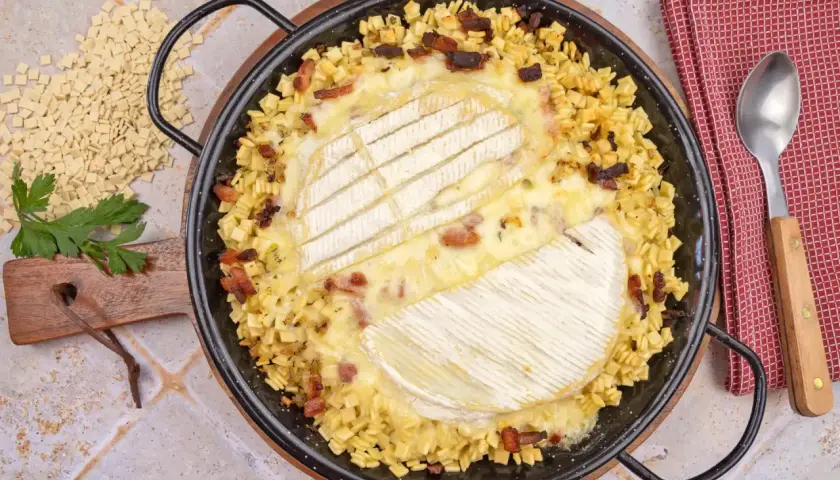 Une délicieuse crozet tartiflette, gratinée au fromage, avec des lardons et des crozets, prête à être dégustée.