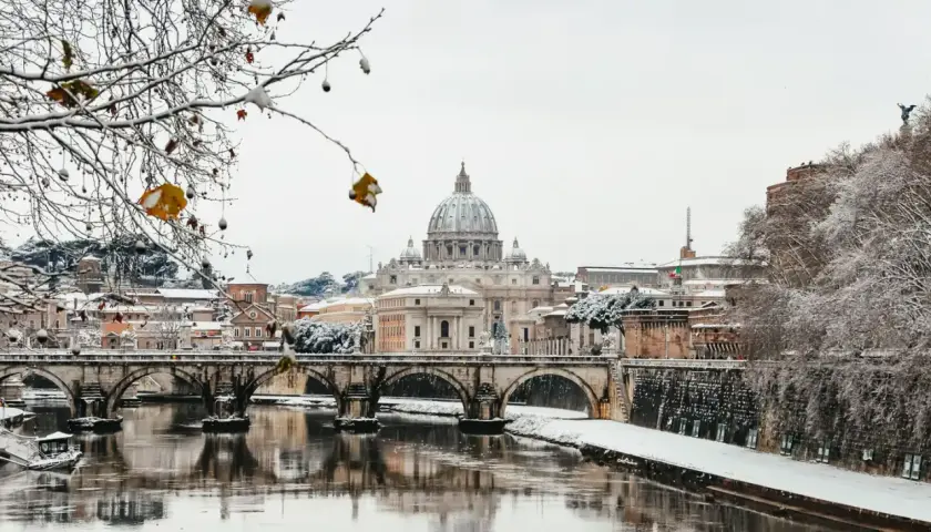 Un raro freddo a Roma imbianca il Tevere e i ponti, con San Pietro sullo sfondo.