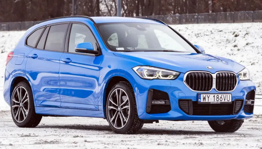 Błękitne BMW X1 2025 na śniegu, gotowe na zimowe wyzwania.