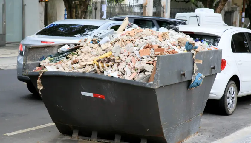 Kontener pełen gruzu budowlanego, cegieł i resztek materiałów. Zastanawiasz się, gdzie wywieźć gruz? Ten widok sugeruje, że problem jest aktualny.