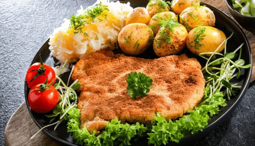 Złocisty kotlet słoneczny, podany z ziemniaczkami, mizerią i pomidorkami. Pyszny obiad!