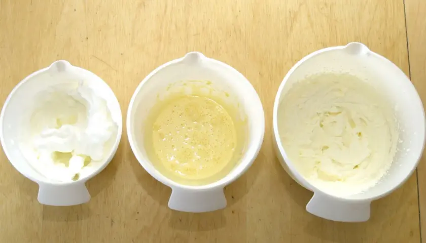 Tre skålar med bakningsingredienser: vispad äggvita, äggsmet och fluffigt smör och socker som vispats poröst.