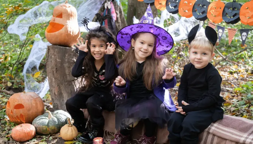 Niños disfrazados de esqueleto, bruja y ratón, listos para pedir dulces. ¡Así se divierten porque se disfrazan en Halloween!