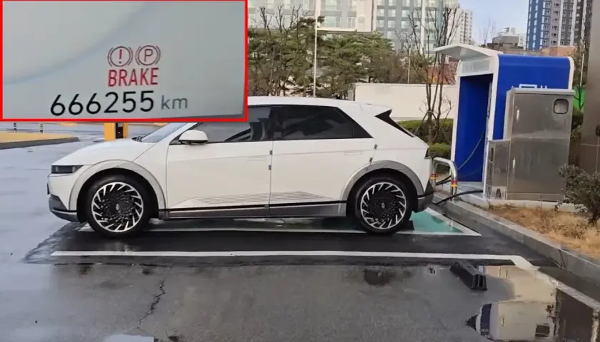 Biały Hyundai Ioniq 5 z przebiegiem 666255 km ładuje się przy stacji ładowania.