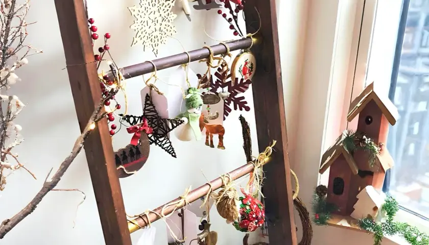 Eine Leiter weihnachtlich dekorieren: Sterne, Schneeflocken, Rentiere und Lichterketten schmücken die Sprossen.