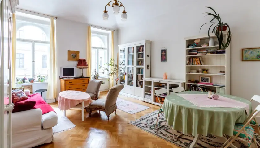 Przytulny salon z kanapą, dwoma fotelami, regałami i stołami. Idealne miejsce na umowa na czas nieoznaczony.
