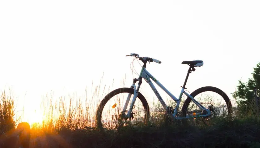 Bicicleta blanca en un prado al atardecer, lista para una aventura de cantabria en bici.