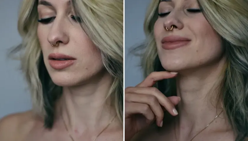 Kobieta z blond włosami i złotym septum piercingiem, z zamkniętymi oczami i delikatnym uśmiechem.