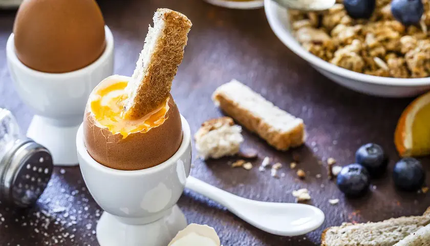 Un œuf cuit à la coque, prêt à être dégusté avec des mouillettes. Un petit-déjeuner gourmand et réconfortant.