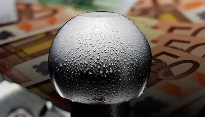 Gocce d'acqua su un gancio traino, con banconote in euro sullo sfondo. Quanto costa omologare un gancio traino?