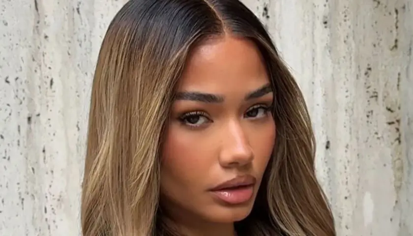 Mujer con cabello castaño oscuro con mechas rubias, un estilo que inspira cómo aclarar el pelo para un look radiante.
