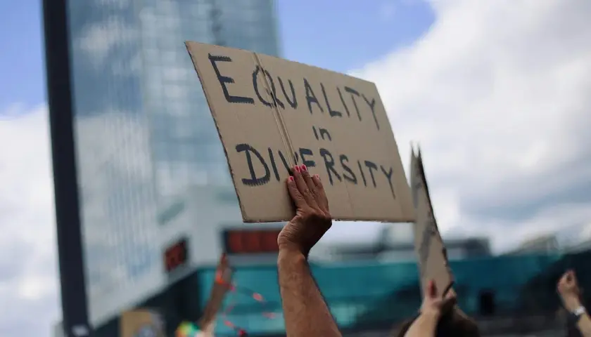 A hand holds a sign reading "EQUALITY in DIVERSITY," a powerful statement that inclusivity is a value.