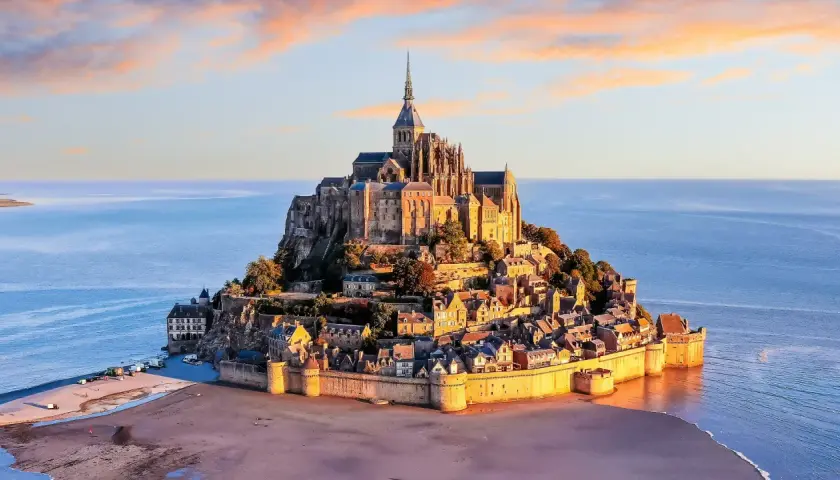 Mont Saint-Michel, jeden z najpiękniejszych zabytków Francji, majestatycznie wznosi się na wyspie otoczonej wodą.