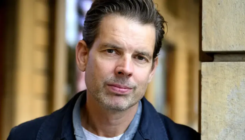 Alex Schulman, en svensk författare och programledare, poserar framför Dramaten.