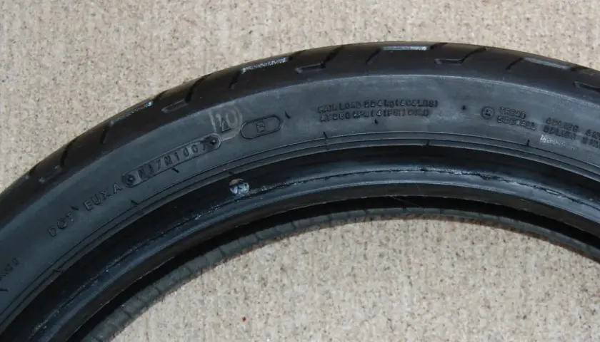 Detalle de la nomenclatura de llantas de motocicleta, mostrando información de carga, presión y composición.