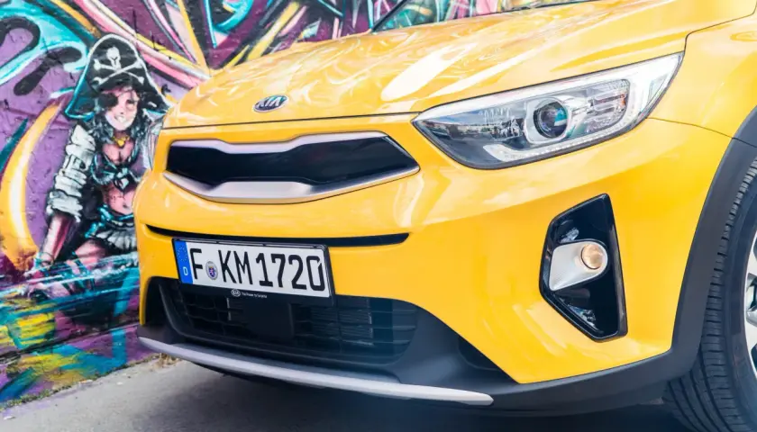 Żółty, stonic kia z pirackim graffiti w tle.