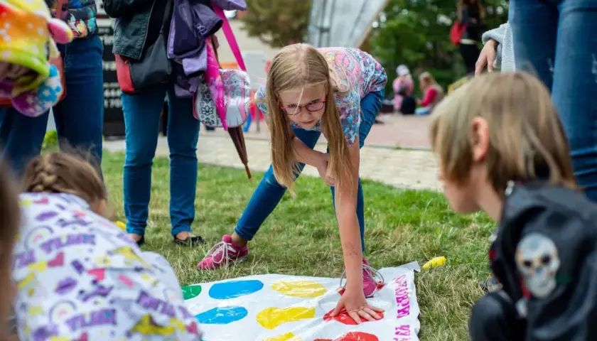 Bambini si divertono con giochi per feste di compleanno 11 anni, giocando a Twister sull'erba.