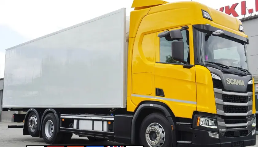 Żółta Scania R z białą naczepą chłodnią, gotowa do dalekich podróży.
