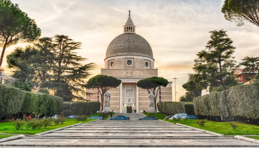 La Basilica dei Santi Pietro e Paolo a Roma, con la sua imponente cupola, si erge maestosa tra alberi secolari e giardini curati.