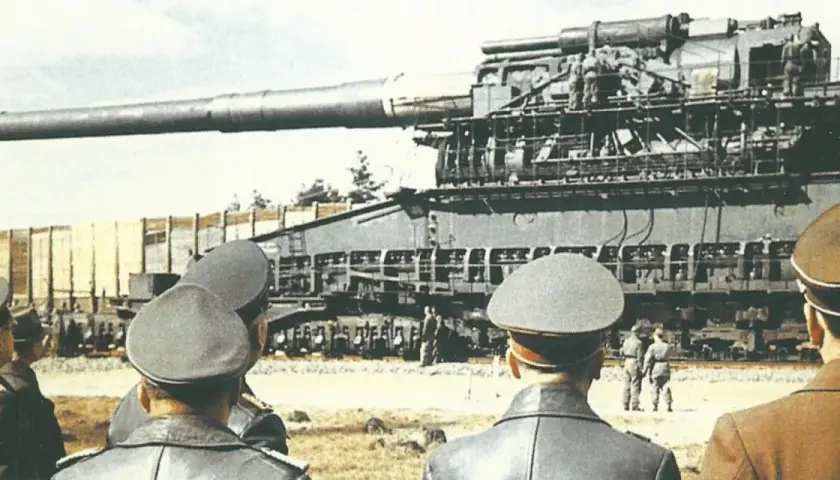 Männer in Uniformen betrachten die riesige Eisenbahngeschütz "Gustav Panzer".