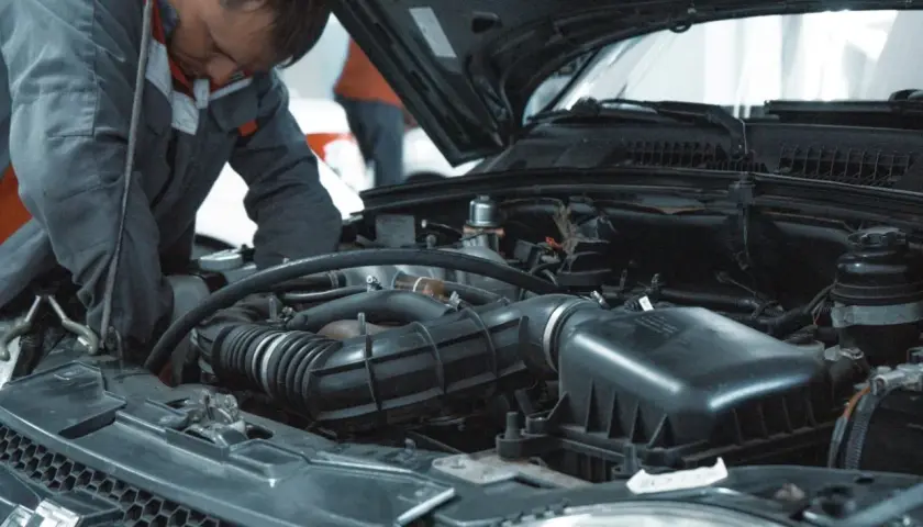 Mechanik pracuje przy silniku. Zastanawiasz się, ile za wymianę oleju i filtrów?