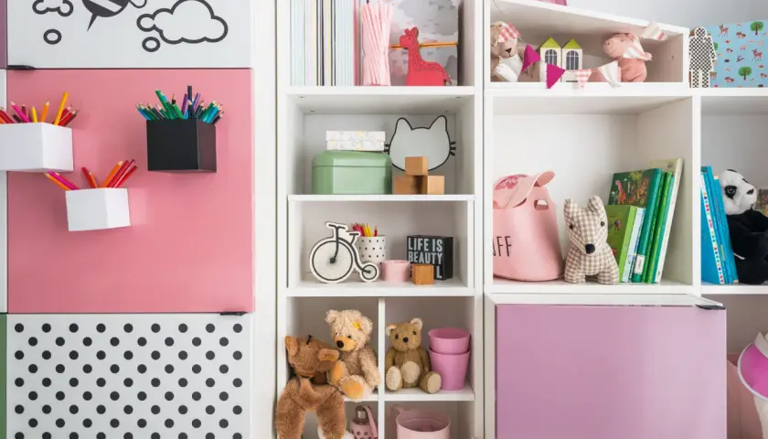 Kolorowe kredki i pluszaki w regale, idealne do przechowywania gier i puzzli.