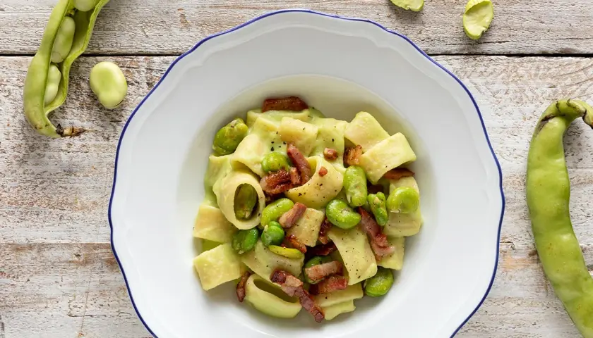 Piatto di pasta con fave fresche e croccante pancetta, un classico saporito.