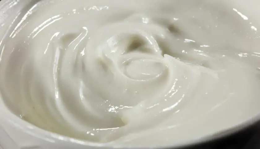 Textura cremosa y suave de alioli con leche, con remolinos que invitan a probarlo.