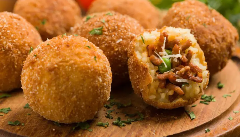Chrupiące arancini, idealne do kuchni włoskiej przepisy. W środku pyszne nadzienie z mięsa i groszku.