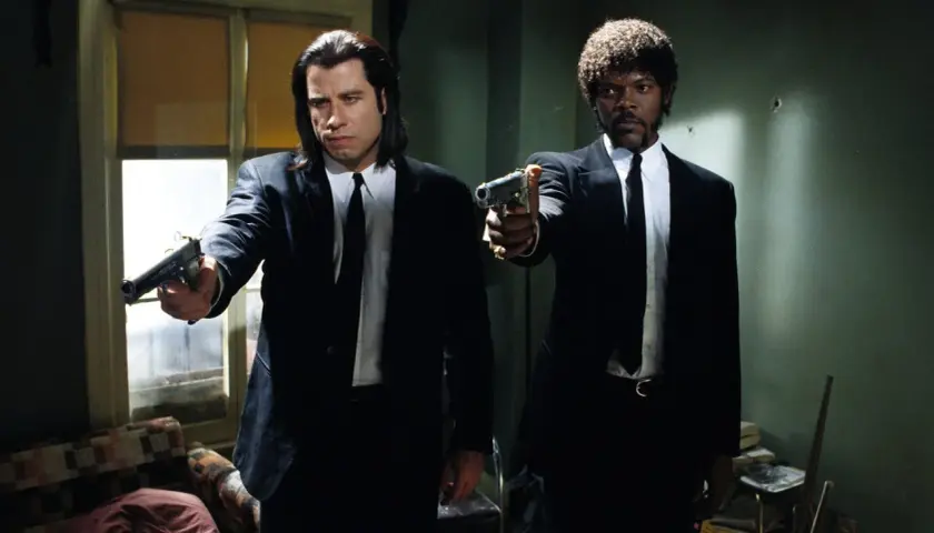 Samuel L Jackson e John Travolta in Pulp Fiction, con pistole puntate, pronti all'azione.