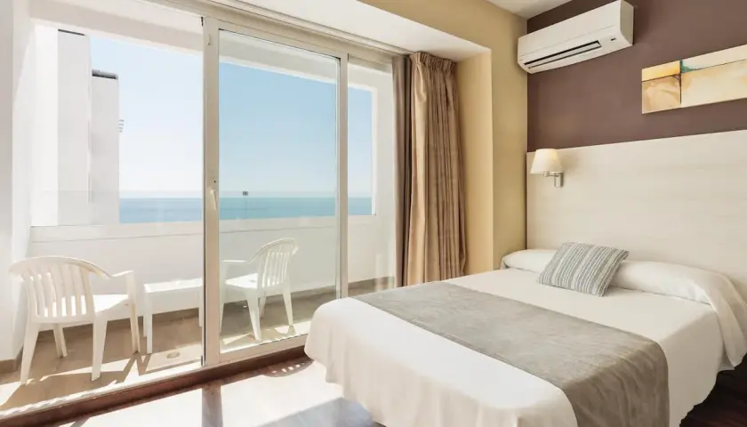 Habitación de hotel con cama, balcón con vistas al mar y aire acondicionado. Las **opiniones** del **hotel Best Indalo** destacan estas comodidades.