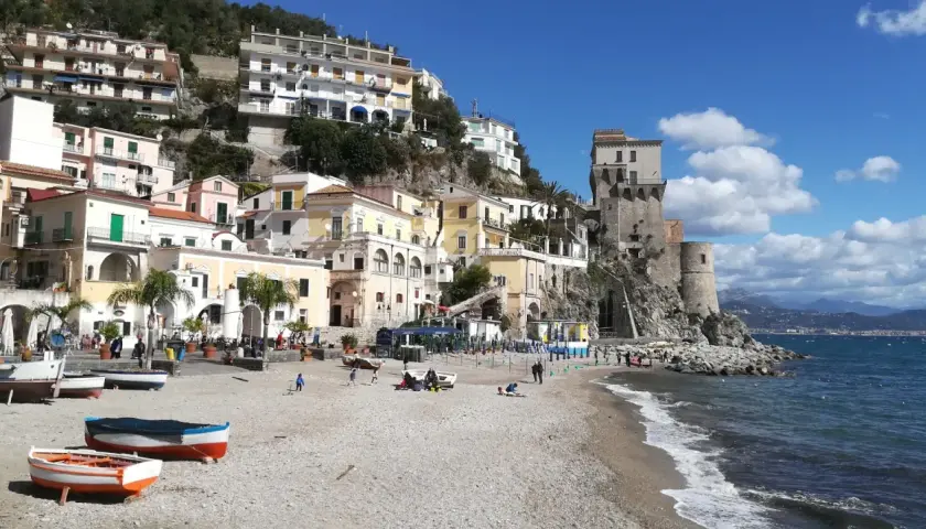 Vue pittoresque de Cetara, Italie, avec ses maisons colorées accrochées à flanc de colline et sa tour médiévale surplombant la mer.