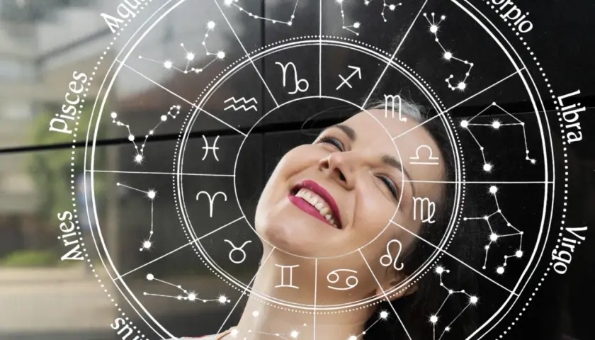 Uśmiechnięta kobieta na tle koła zodiaku. Sprawdź swój horoskop na jutro, zwłaszcza jeśli jesteś Lwem!