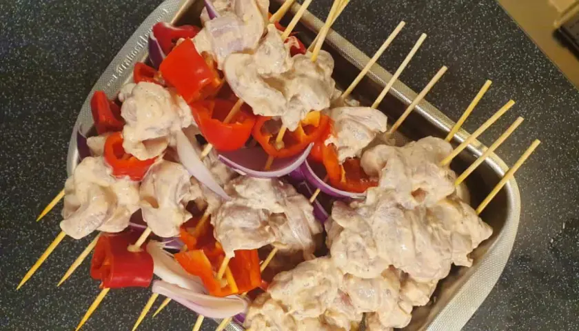 Shish tawook-spett på spett med kyckling, paprika och lök, redo att grillas.