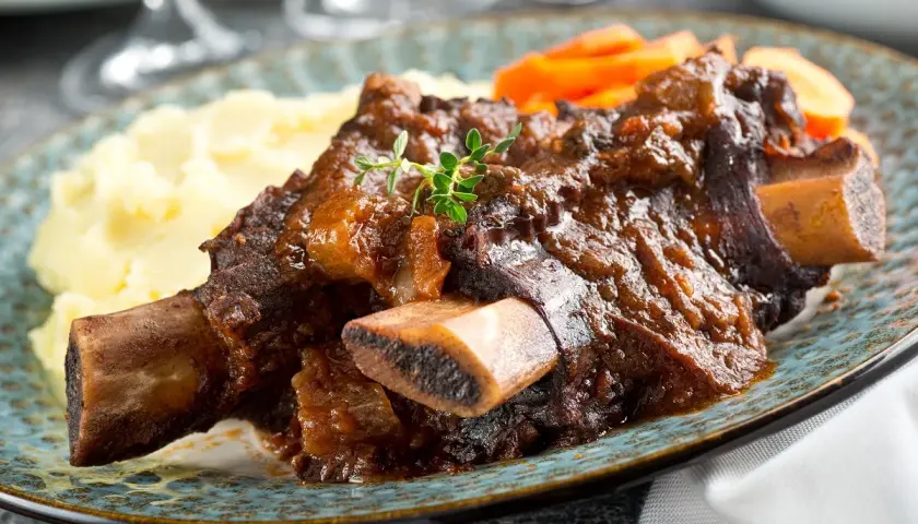 Plat de côte au four, tendre et savoureux, servi avec purée et carottes. Le temps de cuisson est parfait pour cette viande.