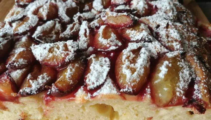 Puszyste ciasto ze śliwkami na oleju, posypane cukrem pudrem. Aromatyczny, domowy wypiek.