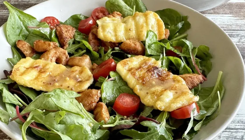 Sałatka z halloumi: chrupiące kawałki sera, pomidorki koktajlowe i świeże liście tworzą apetyczną kompozycję.