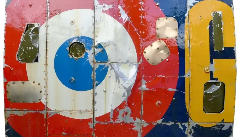 Panneau métallique style pop art, aux couleurs vives et écaillées, rappelant les cocardes d'avions et des chiffres.