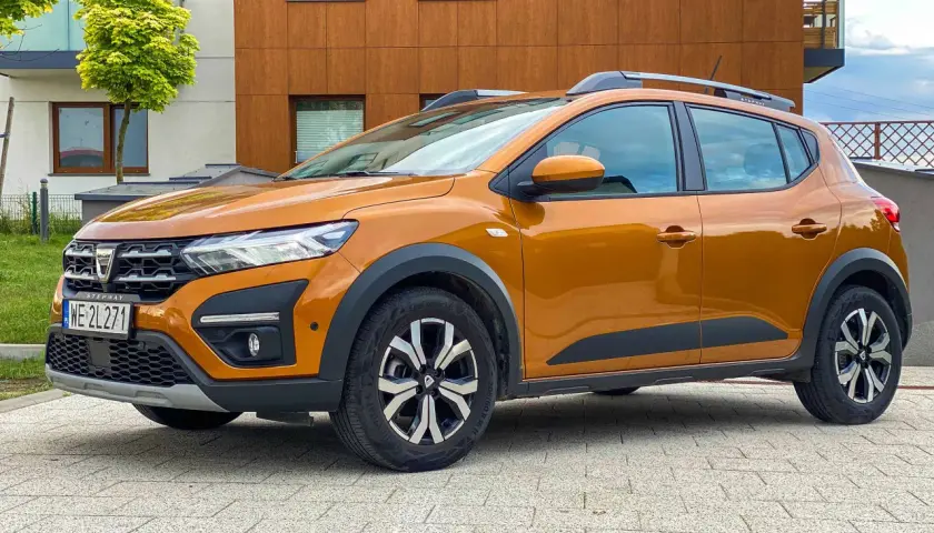 Pomarańczowy Dacia Sandero Stepway na tle nowoczesnego budynku. Zastanawiasz się nad jego spalaniem?