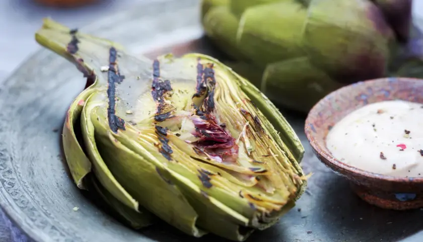 Un délicieux artichaut barbecue, grillé à la perfection, servi avec une sauce crémeuse. Un régal estival !