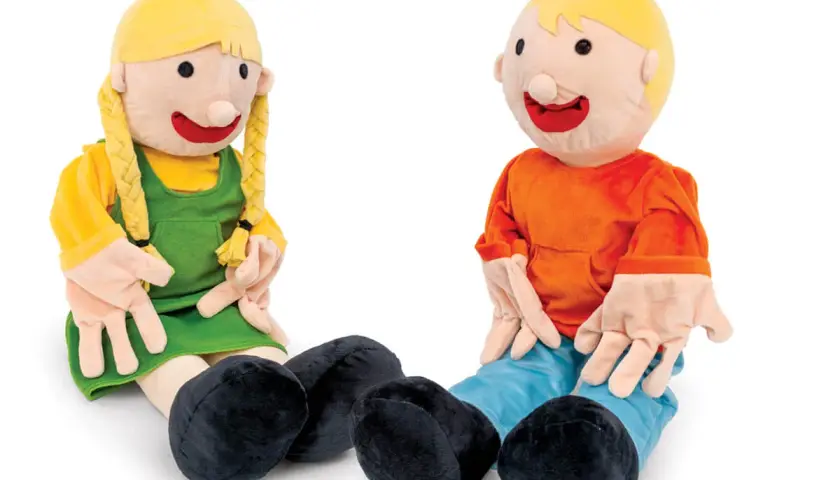 Zwei Stoffpuppen, ein Mädchen und ein Junge, sitzen nebeneinander. Sie sind eine tolle handpuppe als methode für Rollenspiele und zum Erzählen von Geschichten.