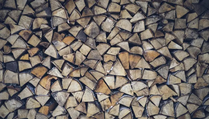 Stapel von gespaltenem Weidenholz, bereit als Brennholz für gemütliche Abende.