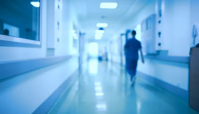 Un medico ospedaliero cammina in un corridoio. Chissà quanto prende di pensione dopo anni di servizio.