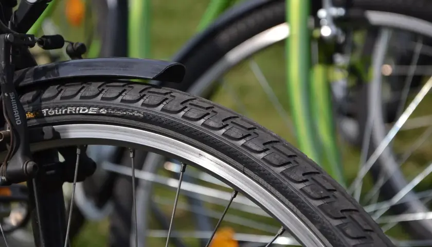 Szczegółowe zdjęcie opony rowerowej z napisem "TourRIDE". Dowiedz się, jak wymienić dętkę w rowerze, by szybko wrócić na trasę.
