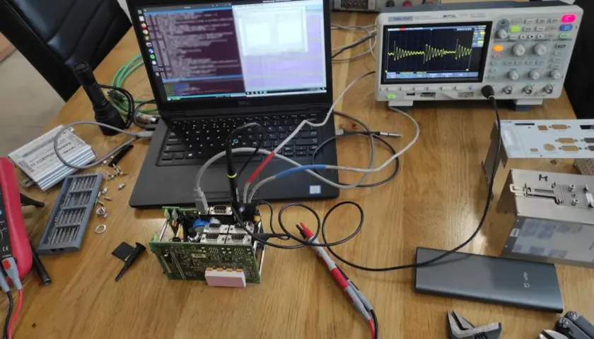 Testowanie układu elektronicznego z użyciem oscyloskopu i laptopa. Widoczne są różne etapy pracy, od podłączenia po analizę sygnału, co pokazuje kolejność faz testowania.