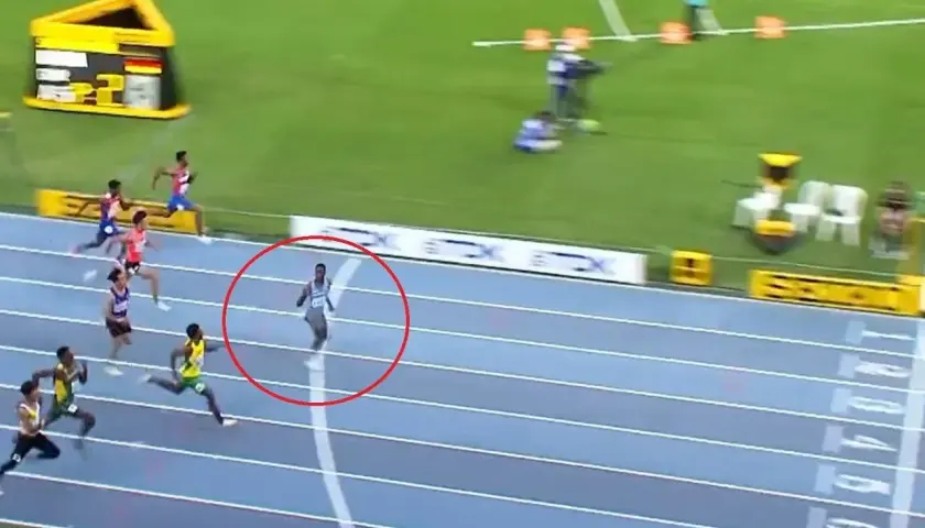 Biegacz w czerwonym okręgu, na bieżni, w trakcie wyścigu na 100 m. Czy to nowy rekord świata?